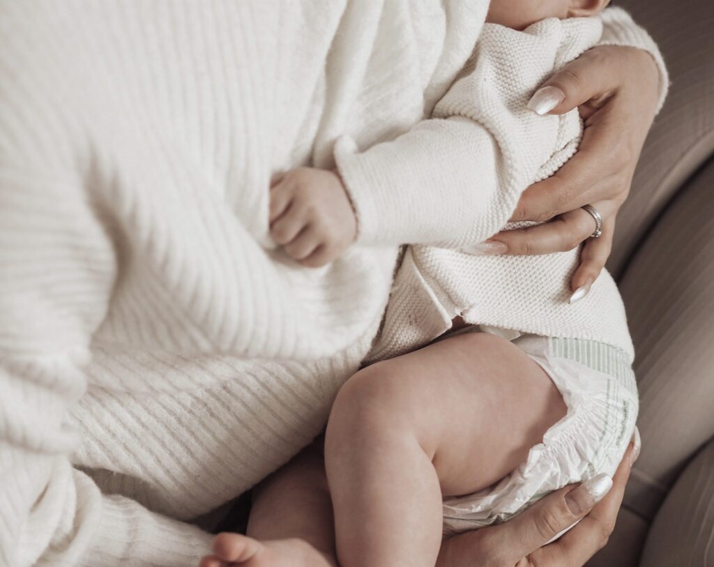 A baby being breastfed in lap.