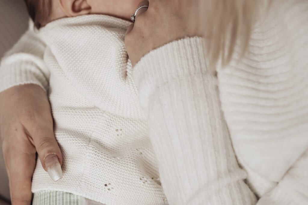 A baby lying on lap.