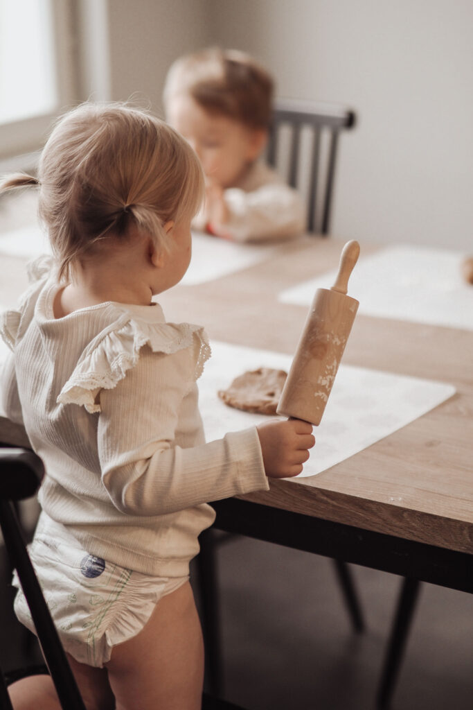 Two children are sitting at the table baking.